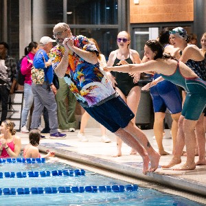 Swimmers kept with tradition and pushed Head Coach, Kent Nelson, in the pool afterward to celebrate.